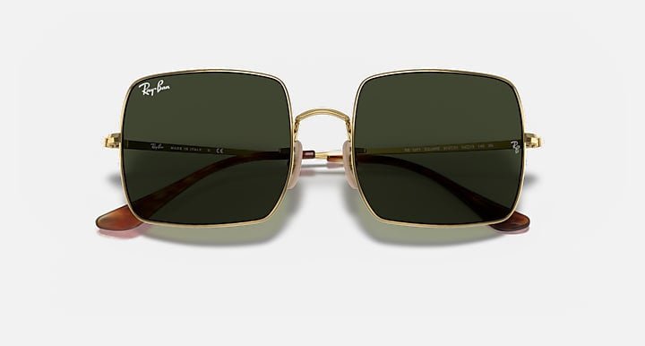 Ray-Ban 1971 Square sunglasses feature oversize square metal frames in polished Arista gold with Havana temple tips and green lenses, shown against a light background.