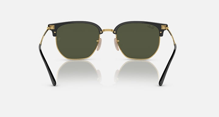 Front view of Ray-Ban 4416 Clubmaster sunglasses with dark green Chromance lenses, gold metal rims, black top frame, and black temple arms on a plain light background.