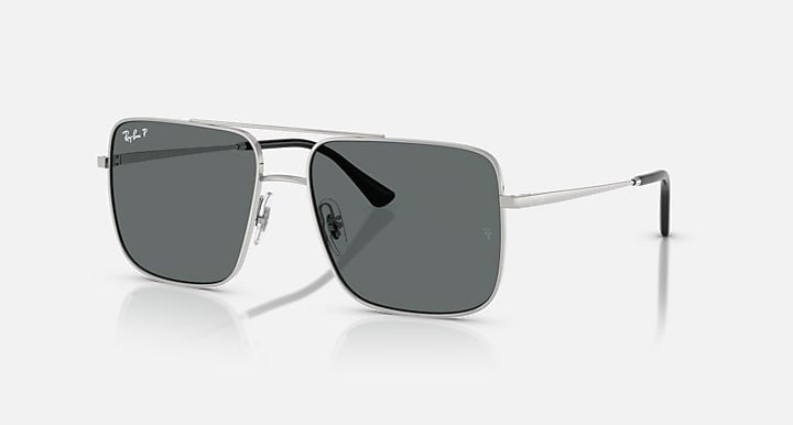 The Ray-Ban Ari sunglasses feature a silver metal frame, dark grey polarized square lenses, thin arms, the Ray-Ban logo on the upper left lens, and reliable UV protection.