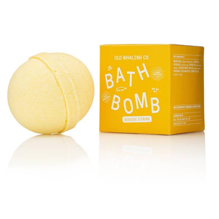 A yellow Bath Bomb | Seaside Citrine by Old Whaling Co. sits beside its matching box, making it perfect for a relaxing soak.