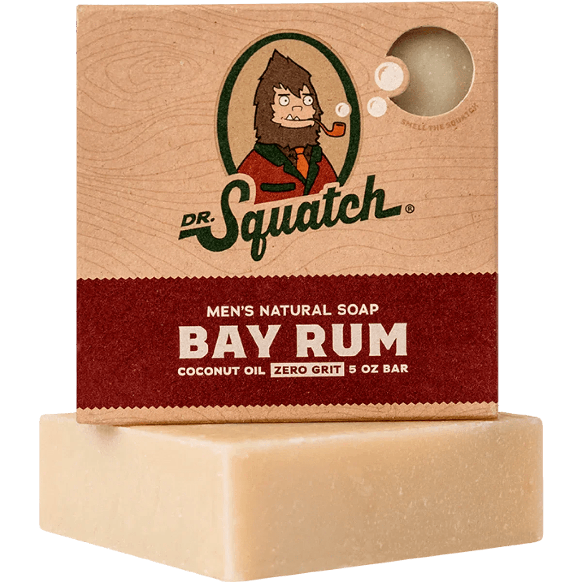 A box of Dr.Squatch Bay Rum Soap sits atop an unwrapped beige bar. The packaging highlights coconut oil, zero grit, and notes of cinnamon for a warm, invigorating scent.