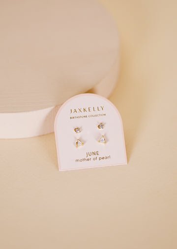 JaxKelly Birthstone Earrings for June feature mother of pearl and hypoallergenic sterling silver posts, shown on a branded card against a pale beige background.