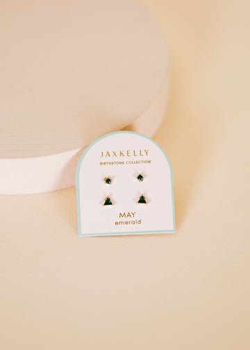 JaxKelly Birthstone Earrings for May feature emerald gemstones and hypoallergenic sterling silver posts, displayed on a white card against a neutral background.