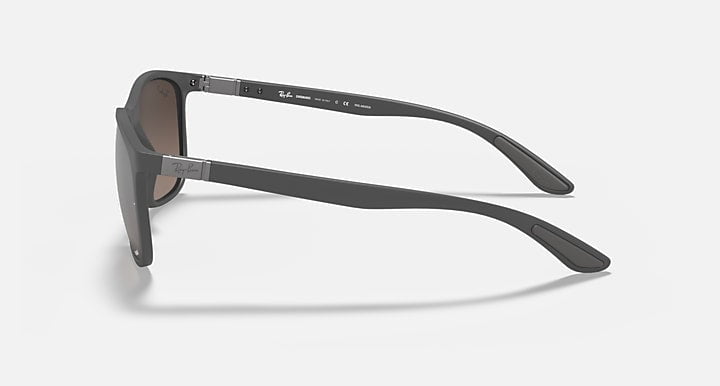Ray-Ban Chromance sunglasses in sand grey with grey mirror silver lenses are shown from a side angle on a plain white background. The Ray-Ban logo is visible, highlighting the stylish and durable design.