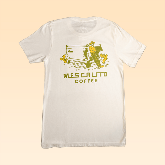 The Coffee Cowboy | Mescalito Coffee shirt by Mescalito Coffee features a white tee with a yellow graphic of a cowboy, coffee machine, cactus, and "Mescalito Coffee" text—perfect for fans of classic cowboy culture.