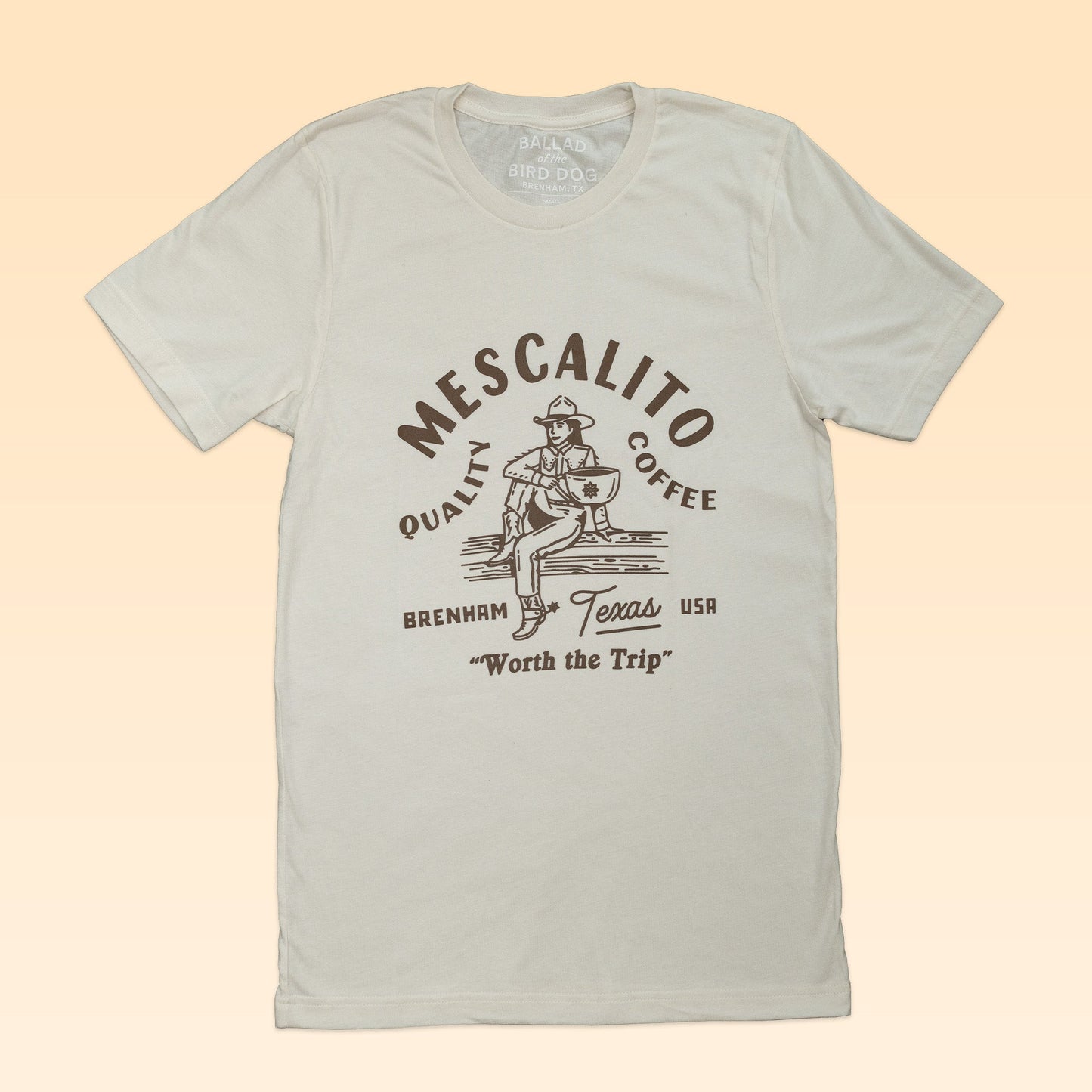 Light gray "Coffee Cowgirl" t-shirt by Mescalito Coffee featuring a graphic and “Mescalito Coffee, Brenham Texas USA, Worth the Trip.” An essential Western-style tee for classic coffee lovers.