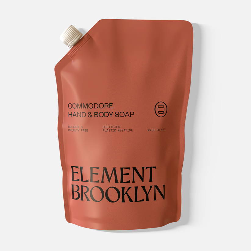 A rust-colored refill pouch labeled "Commodore Hand Soap" by Element Brooklyn, with black text details for an aromatic wash with patchouli notes.