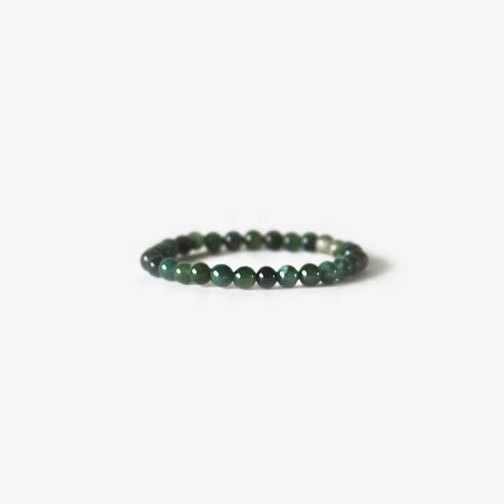 The Earth Bracelet by BRANCO features small, round, dark green agate stones and is shown on a plain white background.