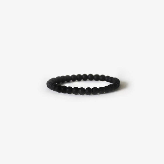 The BRANCO Earth Bracelet features matte black onyx gemstones, elegantly arranged in a circular design and displayed on a plain white background.