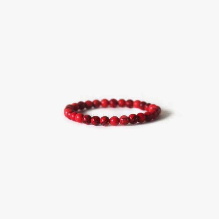 The Earth Bracelet - Red Howlite by BRANCO features elegant, round red beads arranged in a circle, blending the simplicity of beaded jewelry with the refined style of gemstone bracelets.