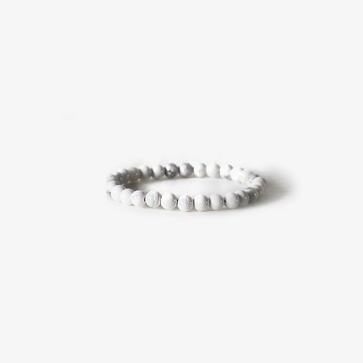 The Earth Bracelet - White Howlite by BRANCO features small, round white howlite gemstone beads in a minimalist design, displayed on a plain white background.