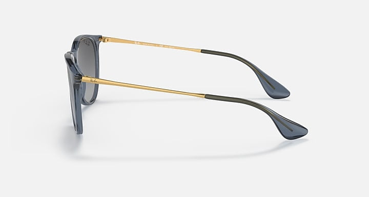 Ray-Ban Erika sunglasses in transparent blue with grey gradient polarized lenses, featuring gold metal arms and 100% UV protection, displayed from the side on a plain background.
