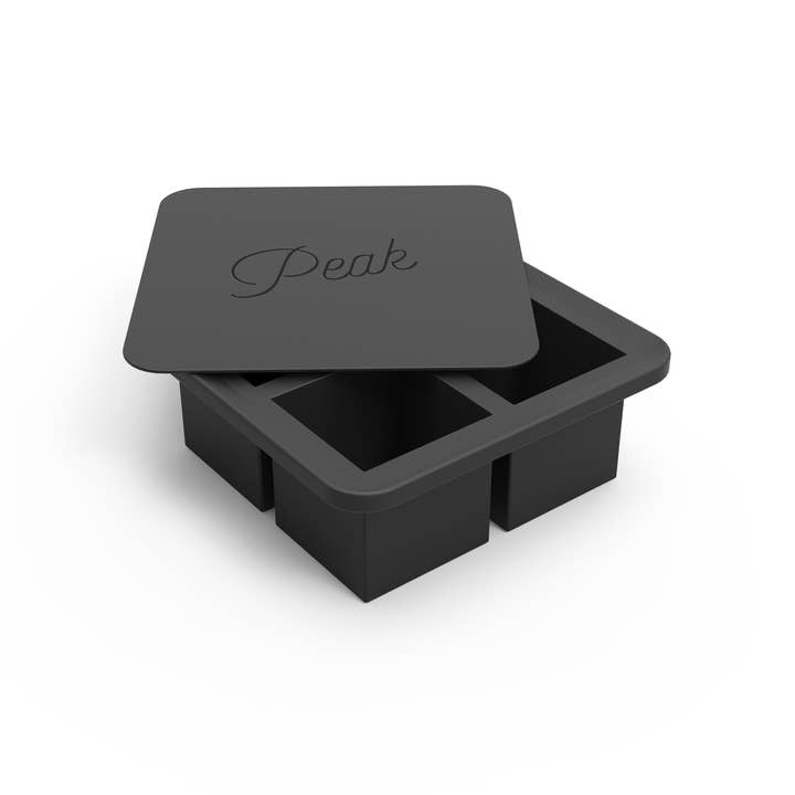 The W&P Extra Large Ice Cube Tray is a black silicone tray with four oversized compartments and a matching lid labeled "Peak.