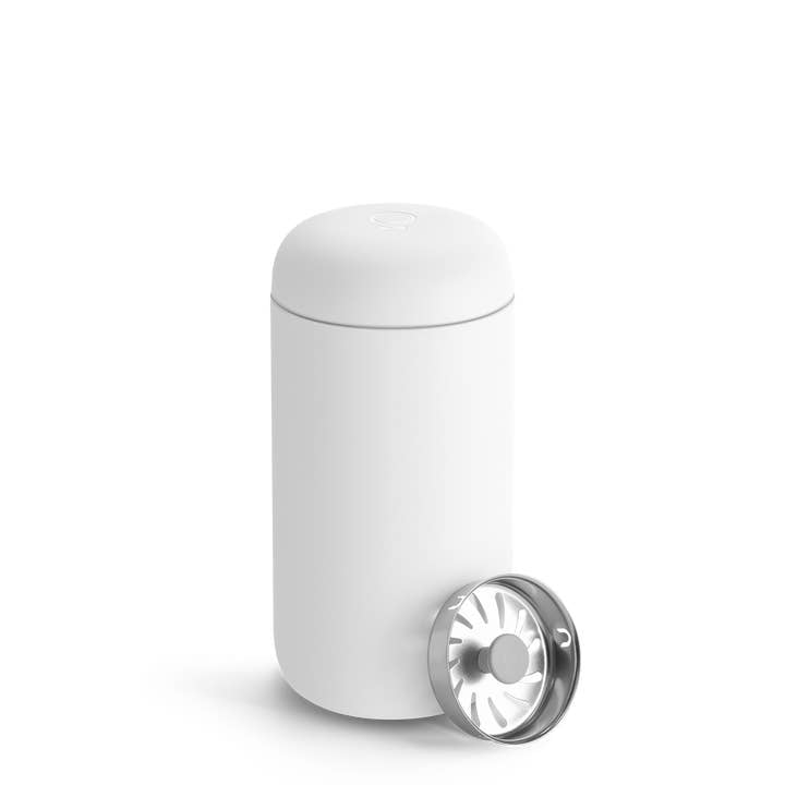 A white Fellow Carter Move Travel Mug, featuring a rounded lid and detachable metal insert, stands upright—crafted as the ideal travel mug or coffee tumbler.