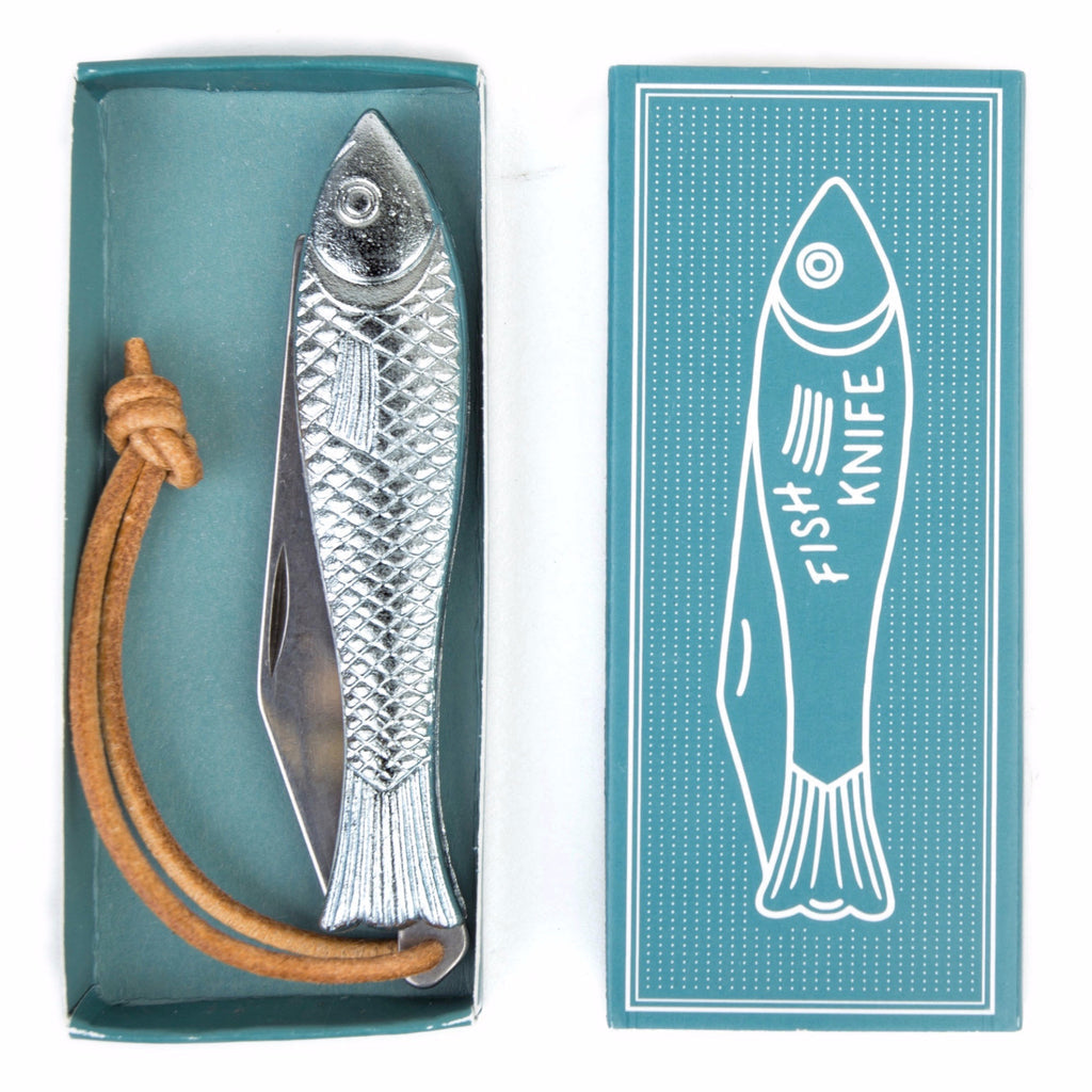 The Mollyjogger Fingerling Fish Knife features a silver chrome handle shaped like a fish, stainless blade, and leather strap. It comes in a teal "Fish Knife" box with a fish illustration—a unique Mollyjogger cutlery piece.