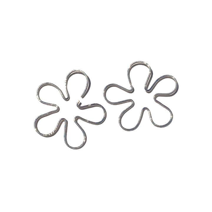 Add a delicate touch to your artisan jewelry collection with the Flower Wire Earrings by Sigfus Designs—two silver metal clips shaped like six-petal flowers, beautifully displayed on a white background.