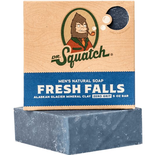 A blue rectangular bar of Dr.Squatch Fresh Falls Soap rests below its box, which highlights Alaskan glacier mineral clay and zero grit for a refreshing clean.