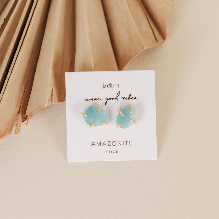 Gemstone Prong - Amazonite - Gold Earrings by JaxKelly: blue amazonite studs with 18K gold plated prongs on a "wear good vibes" and "AMAZONITE hope" card, set against beige. Enjoy tarnish-free amazonite jewelry.