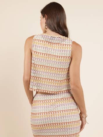 A woman with long brown hair is shown from the back, wearing a small Gilded Sky Front Ties Sleeveless Top and matching high-waisted skirt in neutral tones by Sadie And Sage—an ideal addition to any women’s clothing collection.