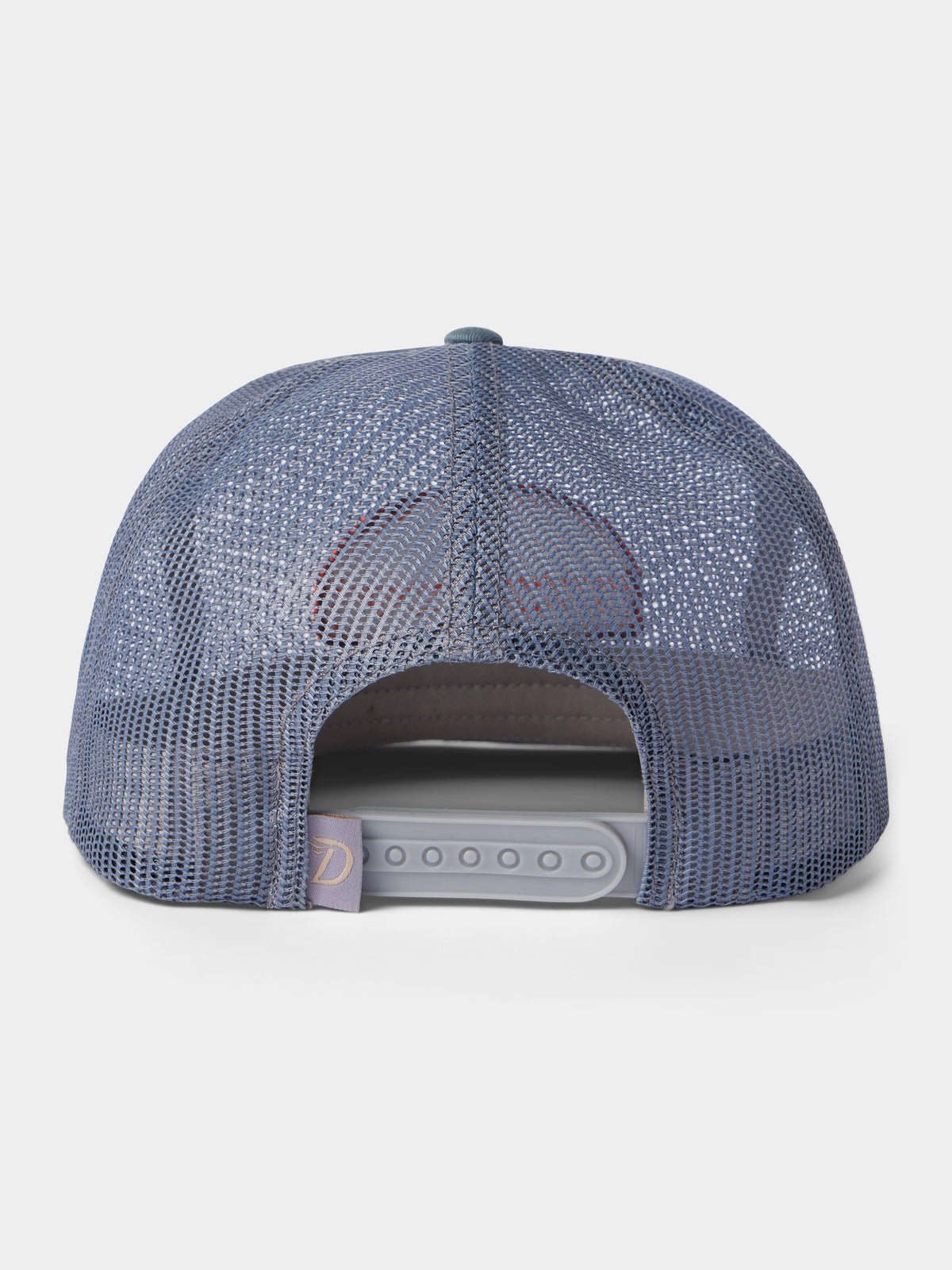 A back view of the Duck Camp Gulf Trucker | Cast & Blast hat in blue, featuring breathable mesh, an adjustable snapback closure, and a small fabric tag on the left side.