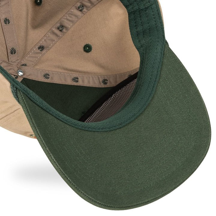 A close-up of the underside of the Hand Tied Flies Hat by Sendero Provisions Co., highlighting its green and beige colors, inner stitching, sweatband, and an embroidered fishing fly design.