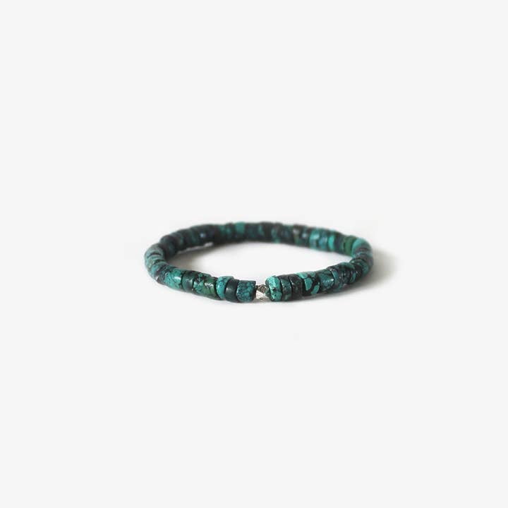 The Heritage Bracelet by BRANCO features small, round turquoise beads, reminiscent of Native American jewelry, elegantly arranged in a circle on a plain white background.