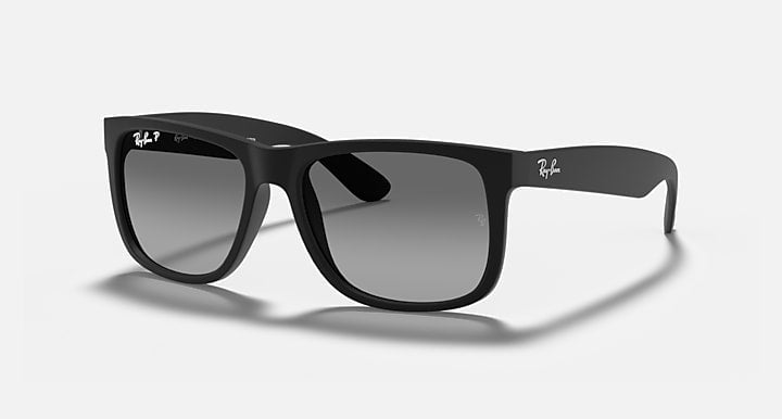A pair of Ray-Ban Justin sunglasses in matte rubber black with light grey lenses, featuring rectangular frames, displayed on a light background.