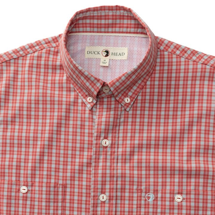 The Duck Head Ls Performance Poplin Guide Shirt is a red and white plaid button-down fishing shirt with a collar, visible buttons, quick-drying fabric, and the Duck Head brand label inside the neckline.