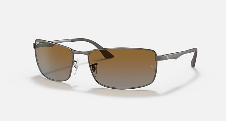 Ray-Ban Matte Gunmetal sunglasses with grey gradient brown lenses and thin brushed aluminum frames, featuring spring-loaded hinges, displayed on a white background.