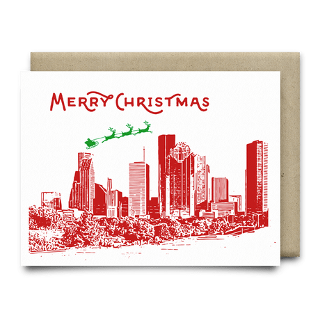The Merry Christmas From Houston Card by Anvil Cards features a red city skyline, "Merry Christmas" above, and Santa’s sleigh in green on linen paper. A2 size, blank inside for your message.