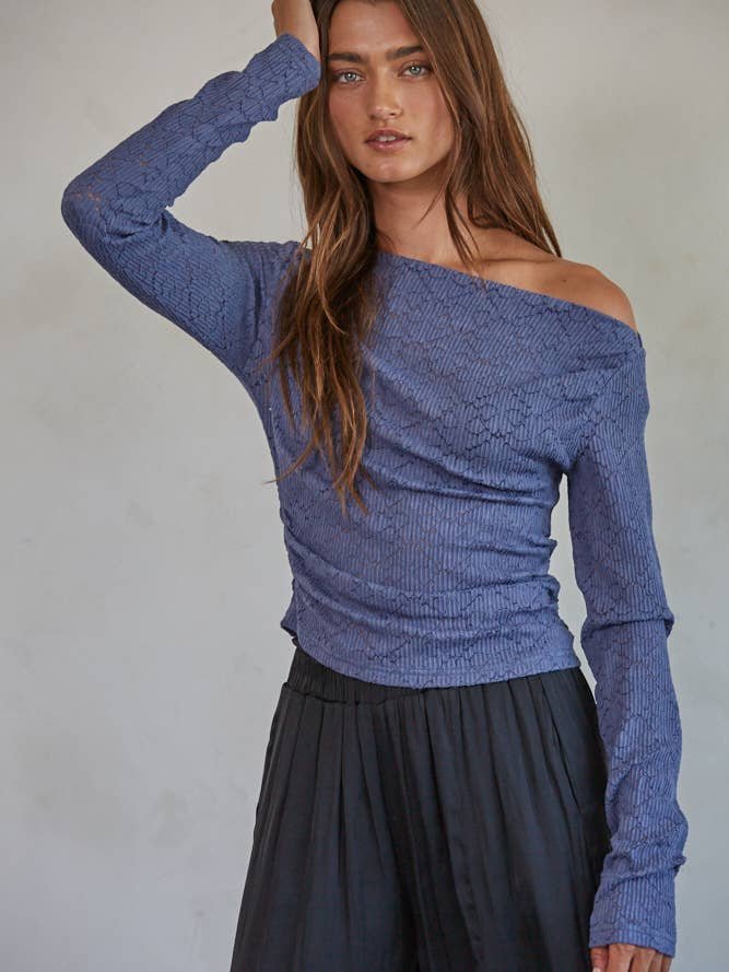 A woman wearing the By Together Off The Shoulder Top with long lace sleeves and a black skirt stands against a plain light background.