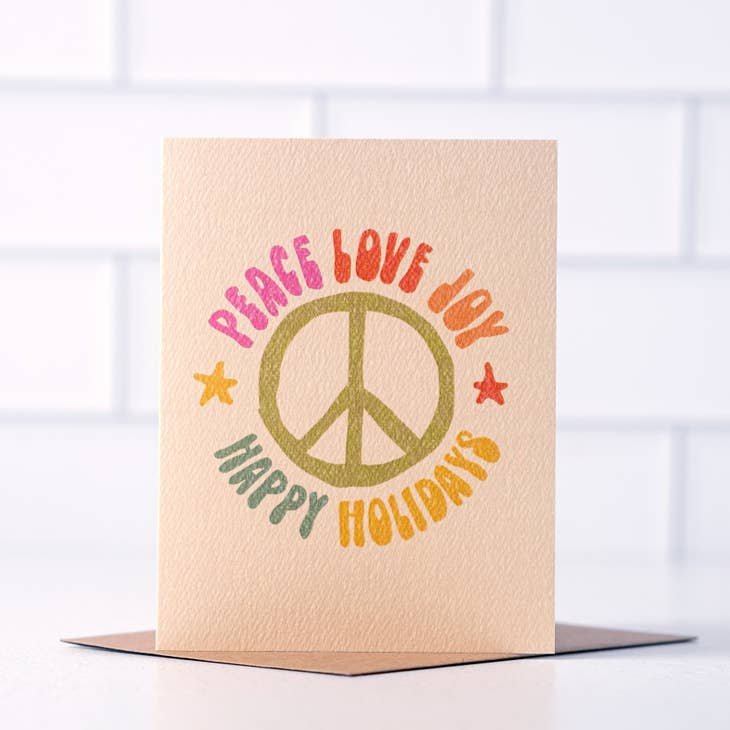Send festive greetings with the Peace Love Joy 70's Style card by Daydream Prints—a retro Christmas card featuring a peace sign and vintage charm.