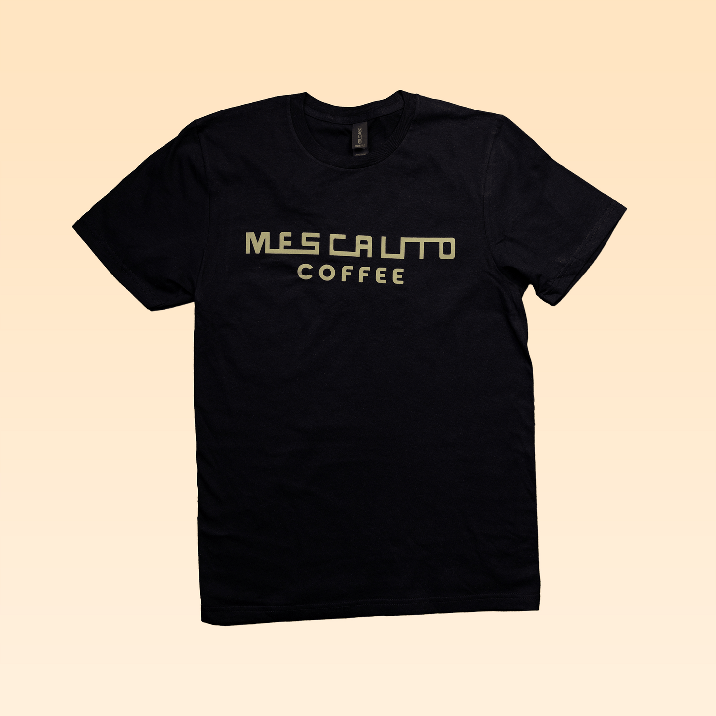 The Retro Mescalito Marzocco t-shirt by Mescalito Coffee features "MESCALITO COFFEE" in light yellow block letters and a retro La Marzocco emblem on black, shown against a beige background.