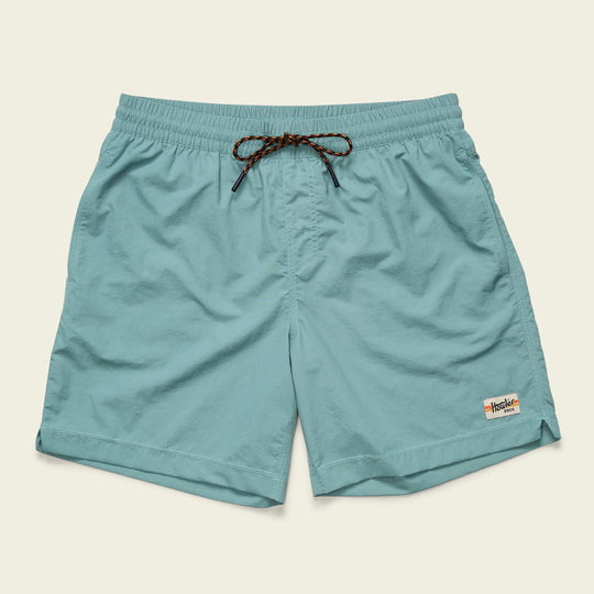 The Salado Shorts Arctic by Howler Brothers are light blue, quick-drying nylon shorts with an elastic waistband, brown drawstring, and a white logo patch on the bottom left hem, shown on a plain background.