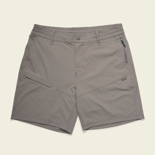 The Shoalwater Tech Shorts by Howler Brothers are light grey 4-way stretch nylon shorts featuring front and side pockets, a button closure, and a right-side zippered pocket, shown flat on a neutral background.