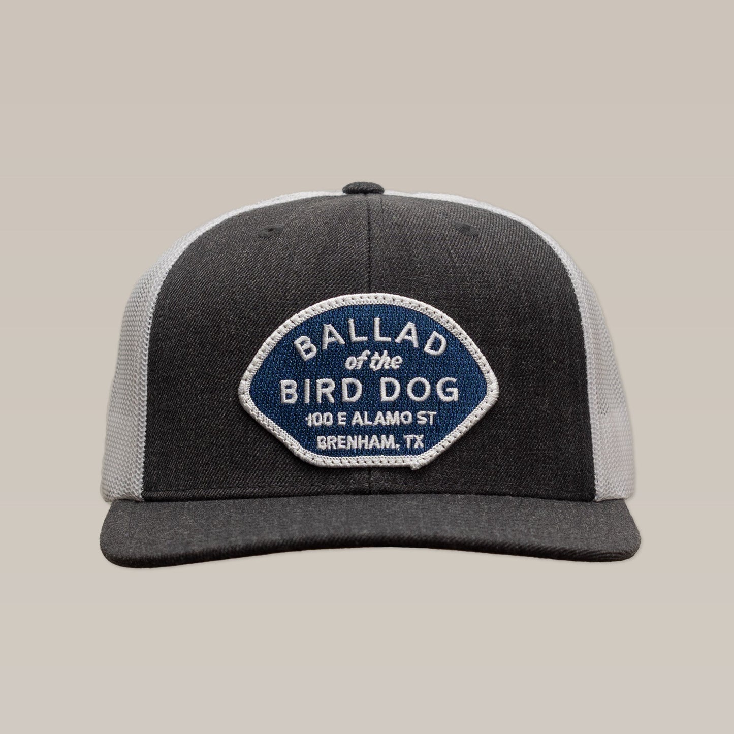 Show your local pride with the Shop Hat | Home Base by Ballad of the Bird Dog—a gray and white hat featuring a blue and white patch reading "Ballad of the Bird Dog, 100 E Alamo St, Brenham, TX" on the front. Perfect for supporting small businesses!.