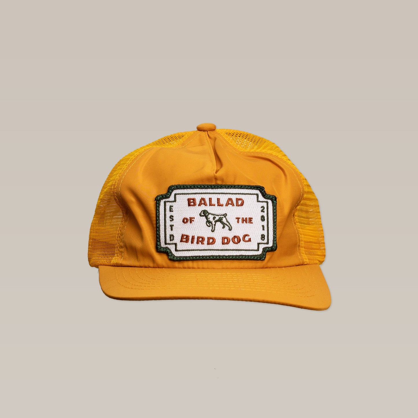 Show your Brenham pride with the Shop Hat | Neon Revival by Ballad of the Bird Dog—a yellow mesh trucker hat with a classic logo patch, "Ballad of the Bird Dog Est. 2018," and a small dog graphic.