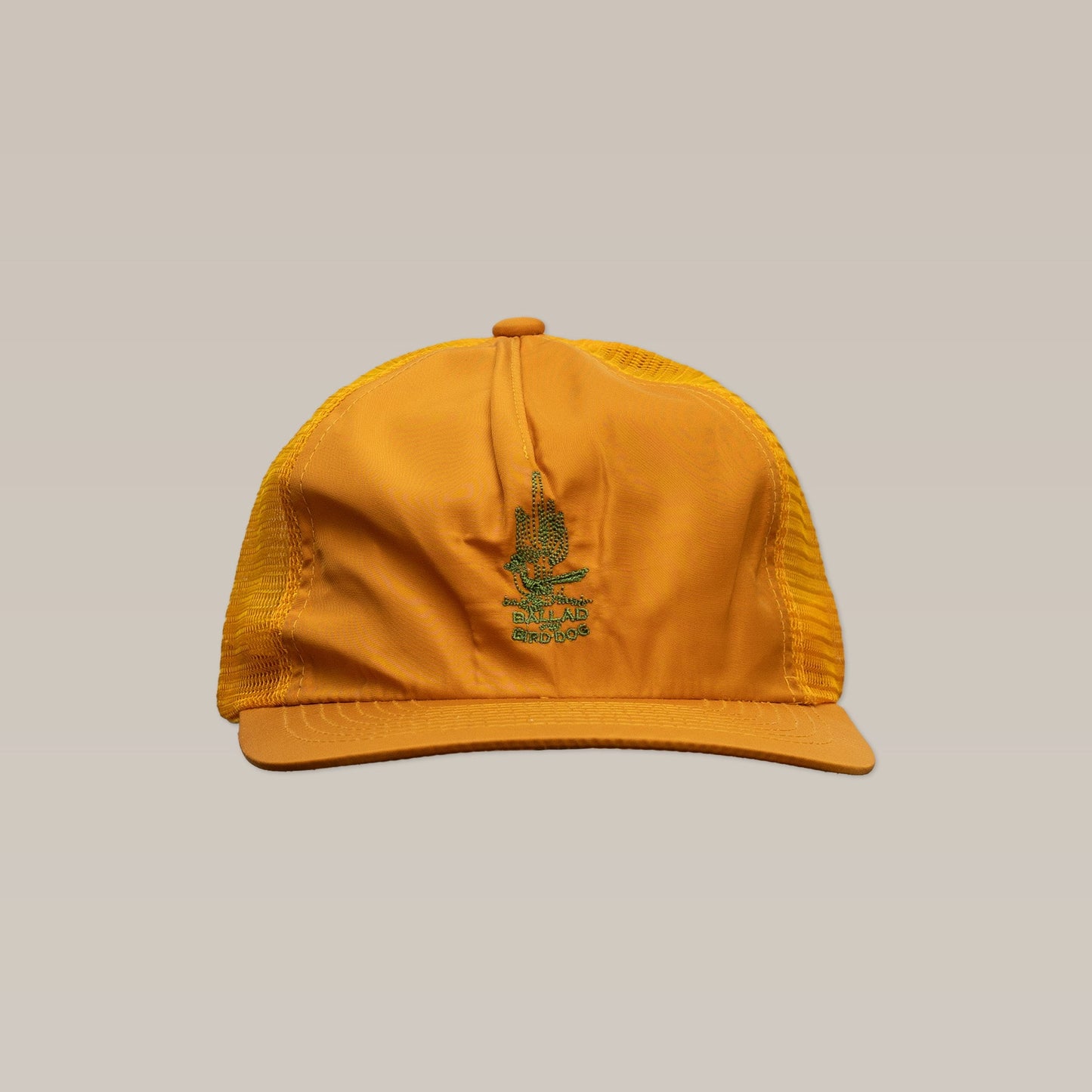 The Shop Hat | Roadrunner Saguaro by Ballad of the Bird Dog is shown in yellow mesh with a green embroidered logo on the front, set against a plain beige background.
