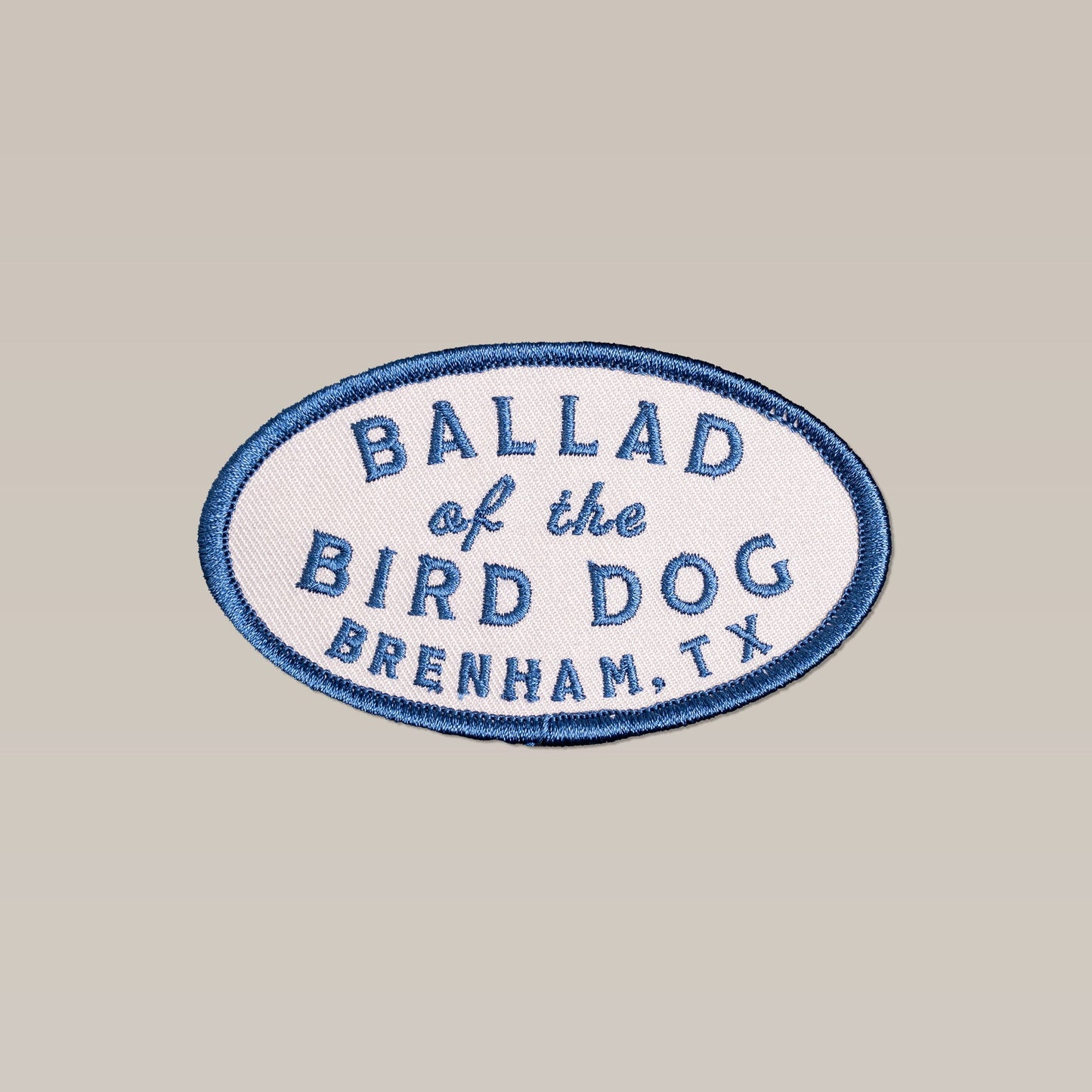 The Shop Patch | Classic Oval by Ballad of the Bird Dog features an oval design with a blue border and "Ballad of the Bird Dog, Brenham, TX" embroidered on a light background.