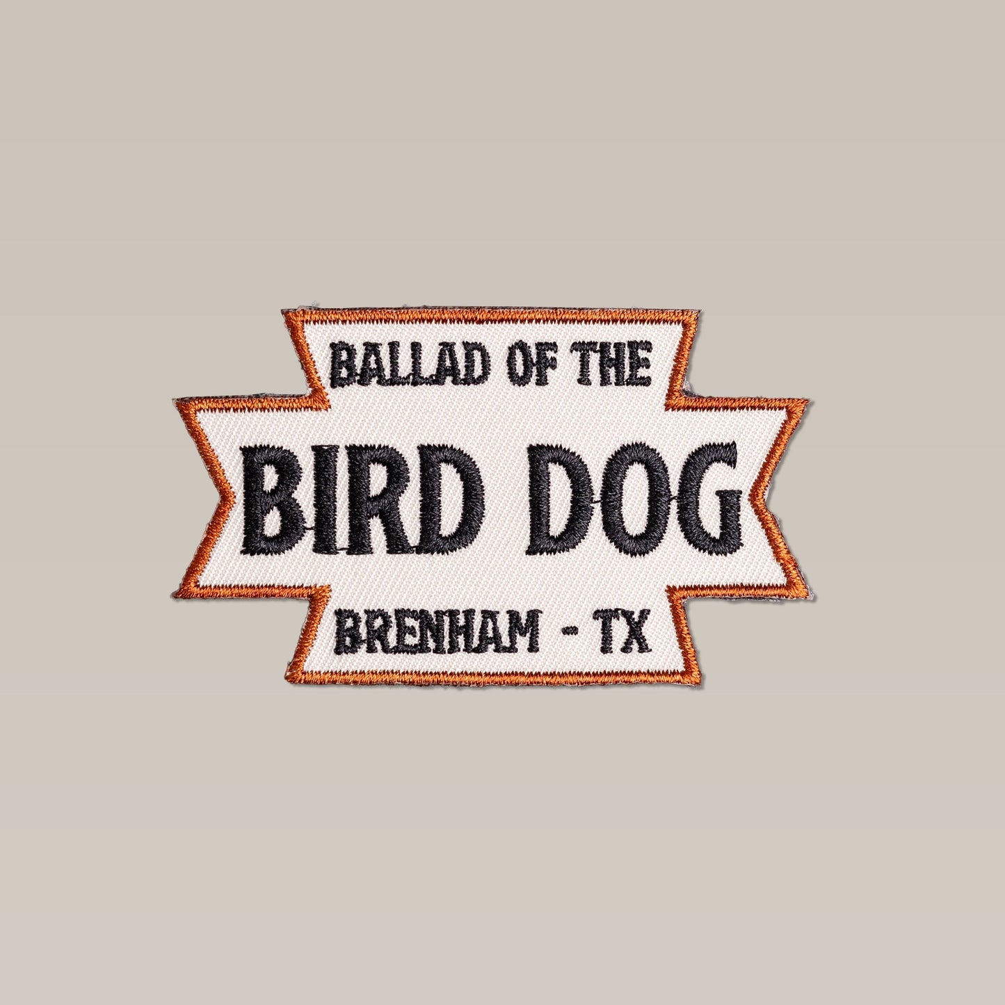 The Shop Patch | Desert Dog by Ballad of the Bird Dog features “Ballad of the Bird Dog Brenham - TX” in black text with an orange border on a light background.