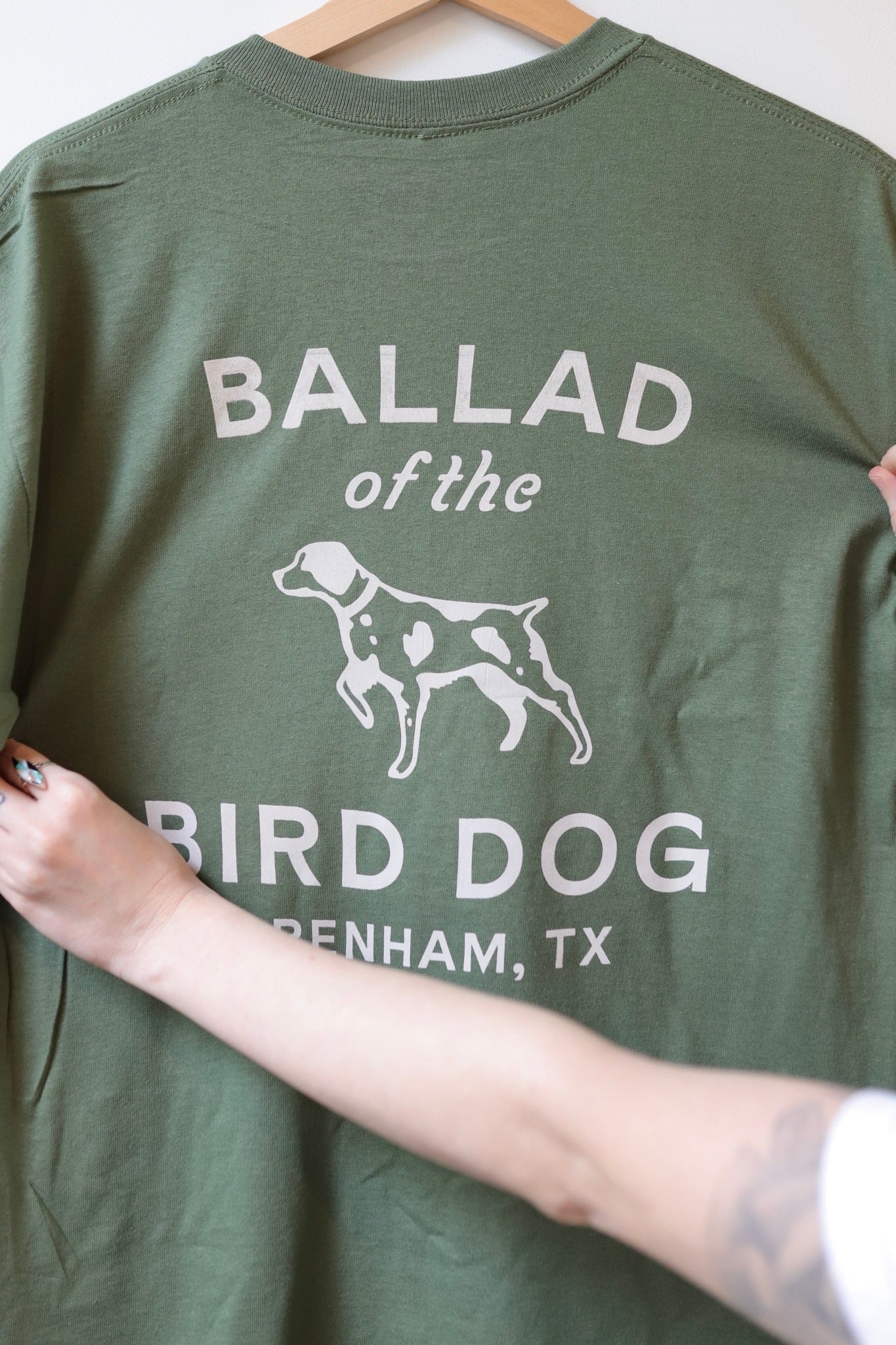 Woman Holding Green Bird Dog Classic Shop Logo Shirt