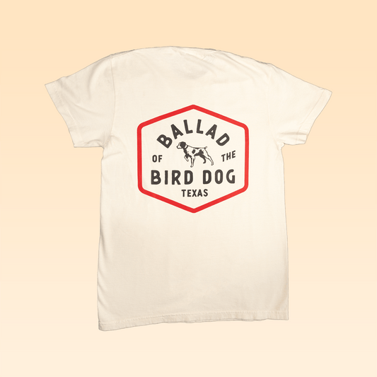 The Ballad of the Bird Dog Shop Shirt | Field Companion features a hexagonal heritage emblem on the back reading "Ballad of the Bird Dog Texas," with a black dog outline inside the logo.