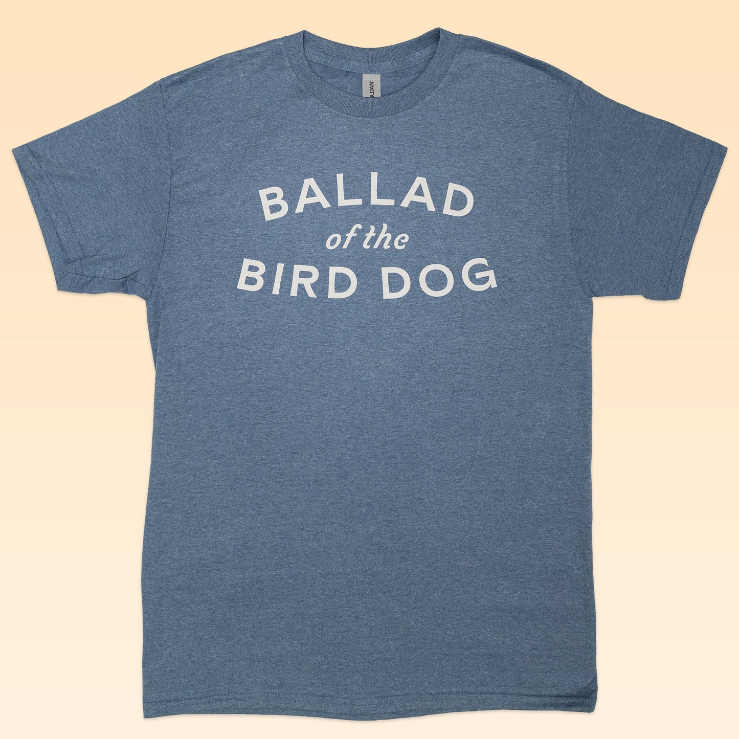 The Shop Shirt by Ballad of the Bird Dog features a heather blue color and bold white "BALLAD of the BIRD DOG" text on front, offering classic, everyday style with the Frontier Oval Logo.