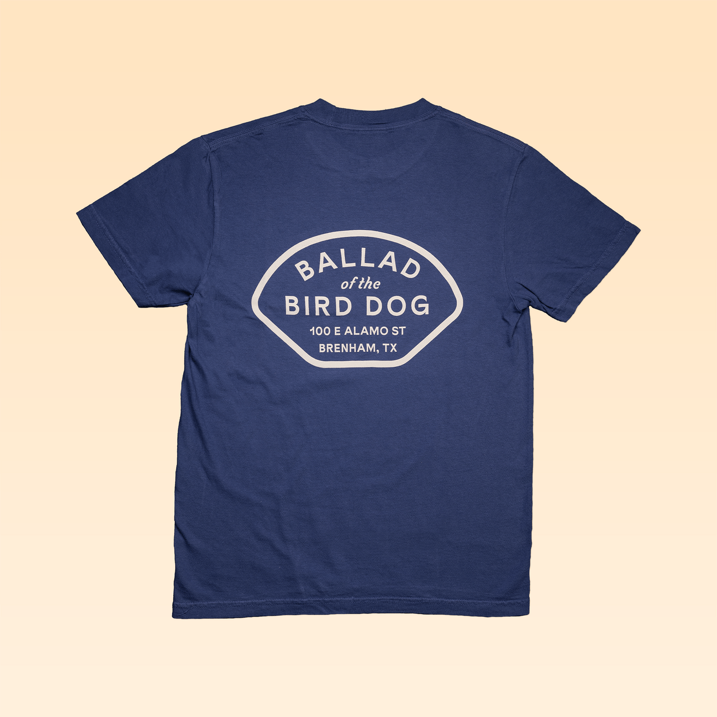 Shop Shirt | Home Base by Ballad of the Bird Dog: navy blue Comfort Colors shirt with "BALLAD of the BIRD DOG, 100 E ALAMO ST, BRENHAM, TX" in white on the back.
