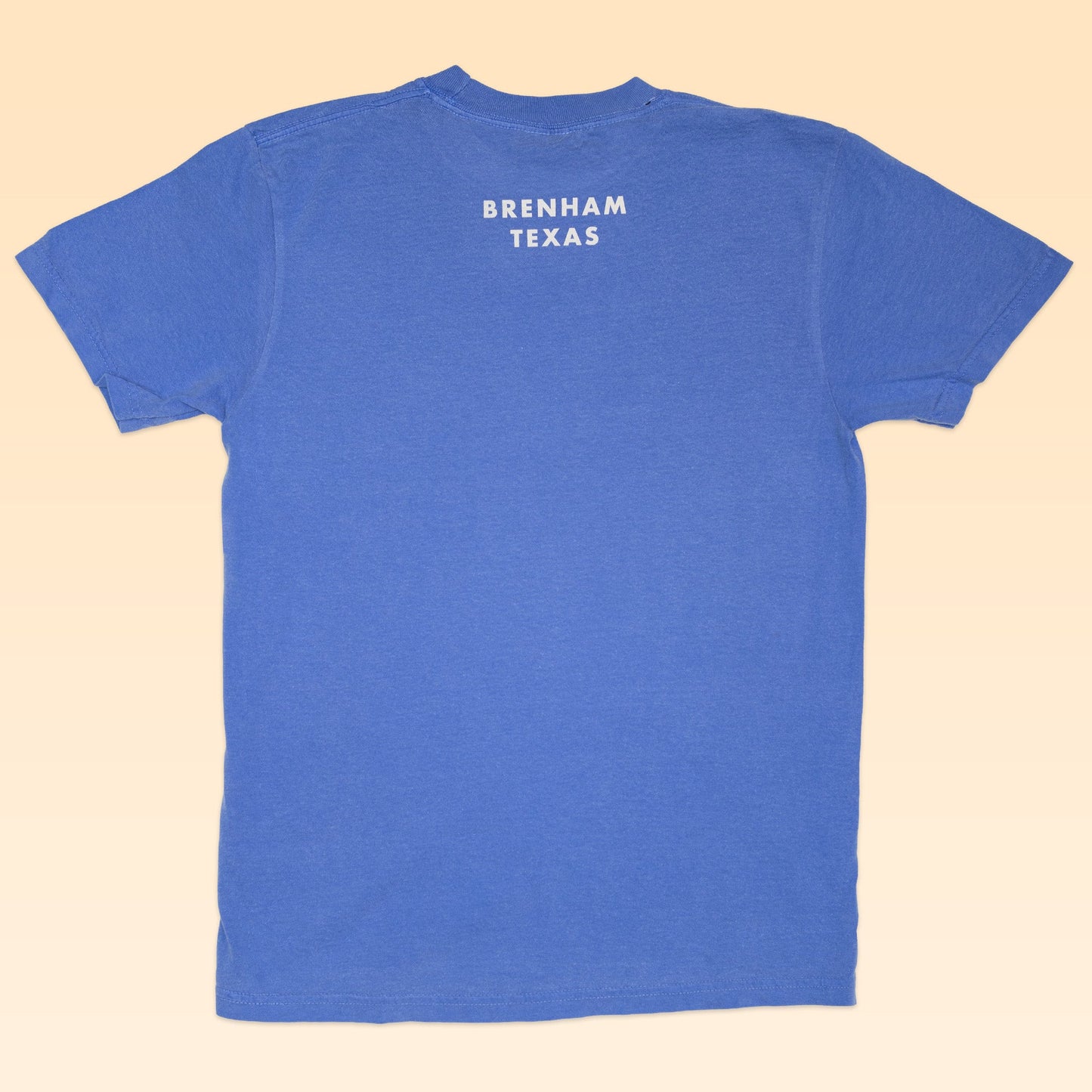 Blue short-sleeve Shop Shirt by Ballad of the Bird Dog, featuring "BRENHAM TEXAS" in white uppercase letters near the neck—ideal for fans of a classic vintage logo look and the Vintage Bird Dog collection.