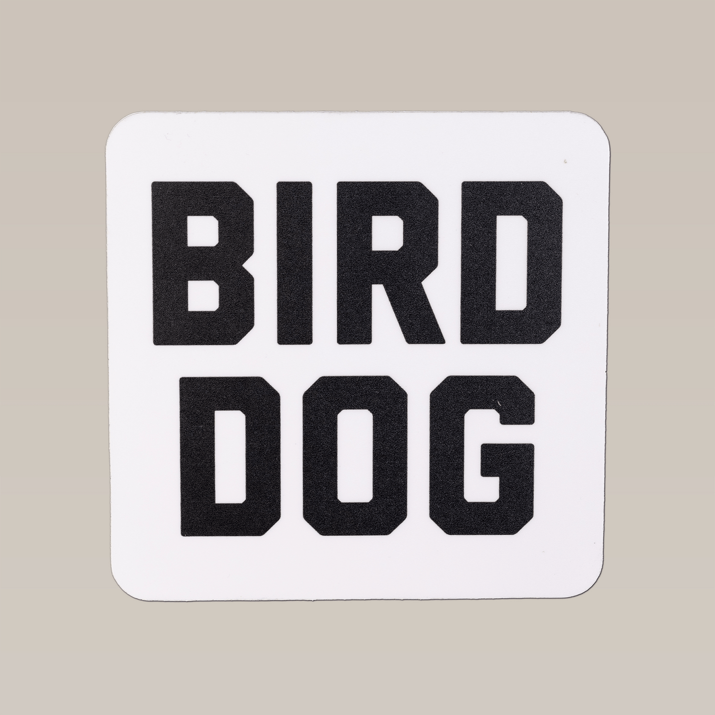 The Ballad of the Bird Dog Shop Sticker | Bird Dog Honor features a square white design with bold black "BIRD DOG" text, perfect for outdoor use and ideal for fans eager to show their hunting companion pride.