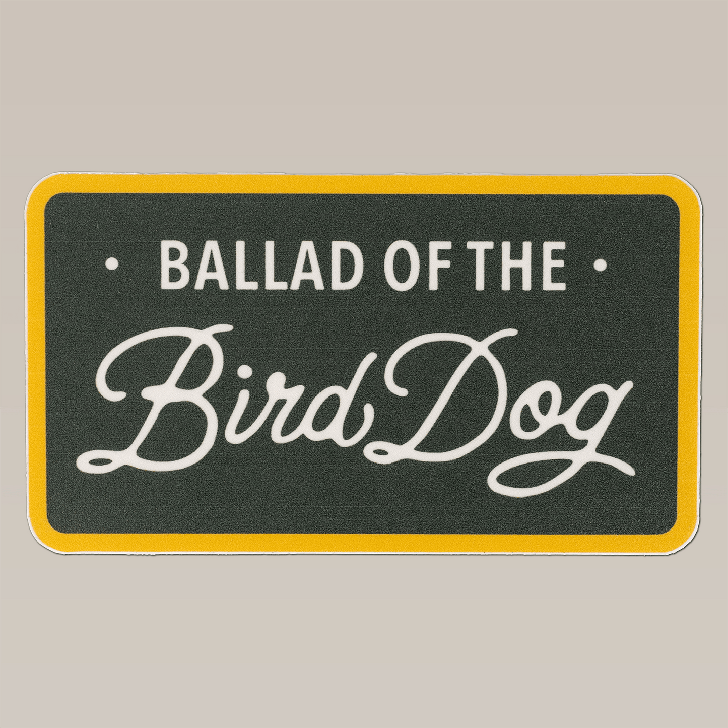 The Ballad of the Bird Dog Shop Sticker features a bird dog plate design with a yellow border and dark background, ideal for fans of durable outdoor stickers from the Ballad of the Bird Dog brand.