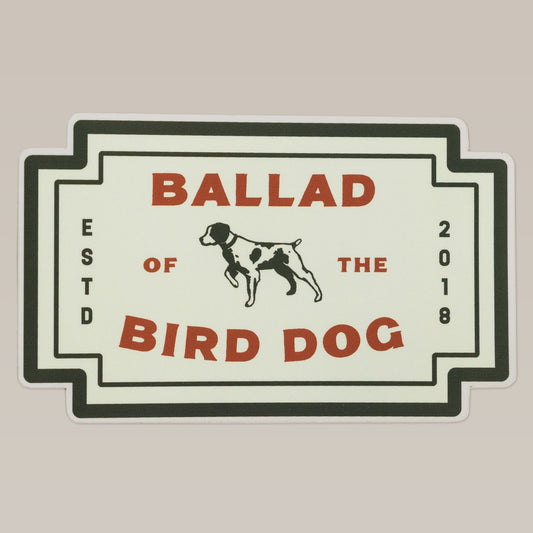 Shop Sticker by Ballad of the Bird Dog features a black and white dog illustration in the center with “Ballad of the Bird Dog” and “ESTD 2018” text, inspired by a classic logo patch. Neon Revival edition.