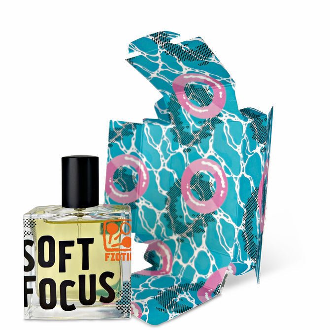 A square perfume bottle labeled "Soft Focus | Fzotic" with a black cap sits before its colorful, abstract-patterned box—a perfect summer fragrance from Fzotic with sandalwood notes.