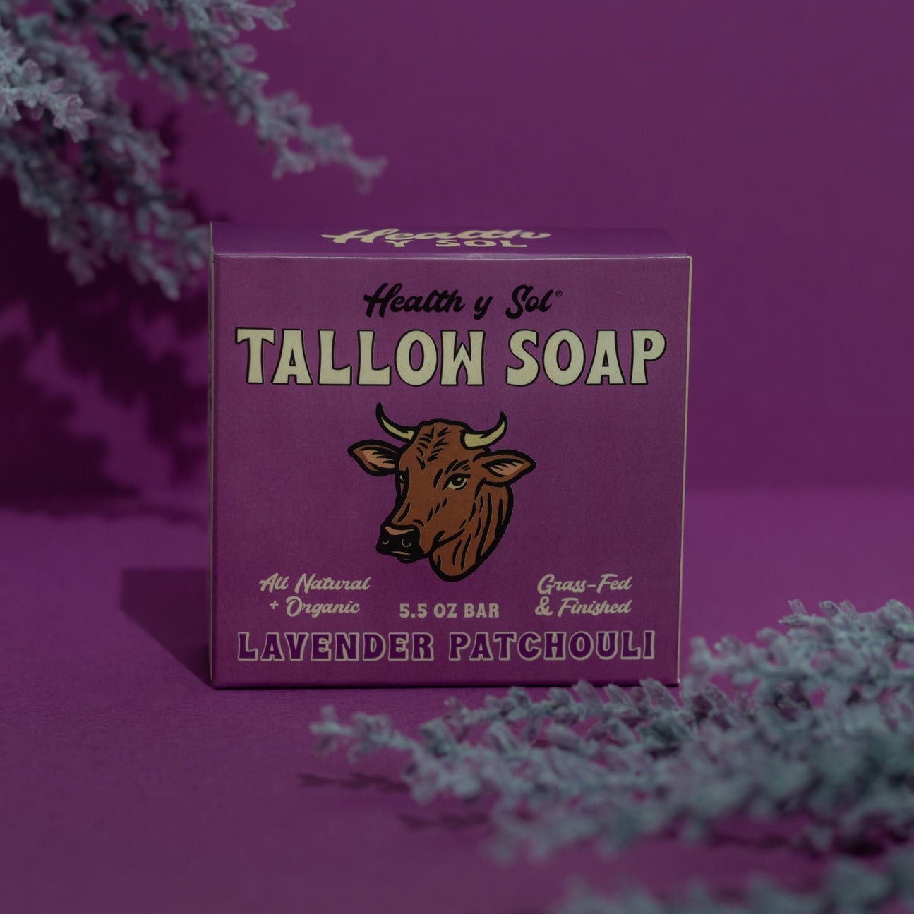 A purple box labeled "Tallow Soap | Health y Sol" with a cow illustration sits on a purple background with lavender sprigs, highlighting its lavender patchouli scent and all-natural ingredients from Health y Sol.
